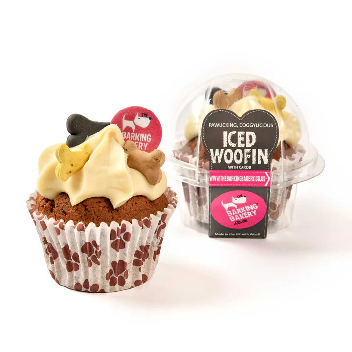 A vanilla iced doggy cupcake with a swirl of frosting, a dog bone decoration, and an edible disc, presented in a paw print wrapper. The product is packaged in a clear recyclable pod with branding labels.